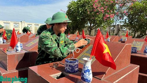 Cán bộ, chiến sĩ Trung tâm Huấn luyện Bộ đội Biên phòng tỉ mỉ lau bia, chỉnh trang từng phần mộ liệt sĩ. Ảnh: Nguyễn Hào