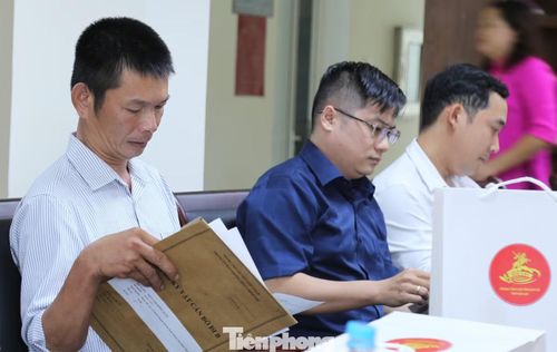 Nhiều người xúc động khi lần đầu tiên sau hơn nửa thế kỷ được cầm trên tay những hồ sơ, kỷ vật của người thân từng bí mật lên đường đi B. Ảnh: Trương Định.