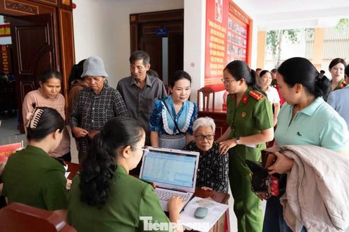 Cán bộ, chiến sĩ công an hướng dẫn bà Vũ Thị Thạnh kê khai thông tin.