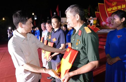 Đồng chí Vũ Quyết Tiến, Phó Bí thư Tỉnh ủy, Chủ tịch Ủy ban MTTQ tỉnh Quảng Ninh trao tặng những bức ảnh chân dung liệt sĩ được phục dựng tới thân nhân các gia đình.