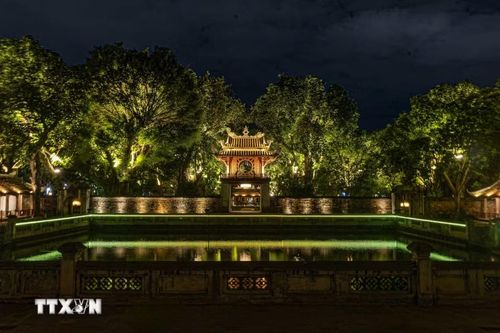 Khuê Văn Các và Hồ Văn được thắp sáng lung linh trong tour đêm "Tinh hoa đạo học" tại Văn Miếu-Quốc Tử Giám. Việc nâng cấp hạ tầng chiếu sáng nghệ thuật tại các di sản trọng điểm không chỉ tạo nên diện mạo mới ấn tượng cho Thủ đô về đêm mà còn là bước đi quan trọng trong chiến lược phát triển kinh tế đêm gắn với du lịch văn hóa. (Ảnh: Tiến Long/TTXVN phát)