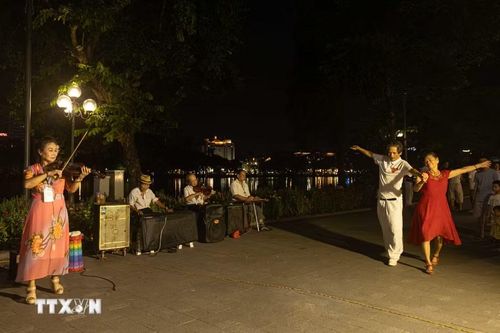 Người dân và du khách hào hứng tham gia hoạt động khiêu vũ, giao lưu âm nhạc bên không gian đi bộ Hồ Hoàn Kiếm. Các nhóm nghệ sĩ tự do và câu lạc bộ nghệ thuật cộng đồng thường xuyên duy trì biểu diễn vào cuối tuần, góp phần nâng cao đời sống tinh thần và tạo nét đẹp văn hóa đặc trưng cho kinh tế đêm Hà Nội. (Ảnh: Tiến Long/TTXVN phát)