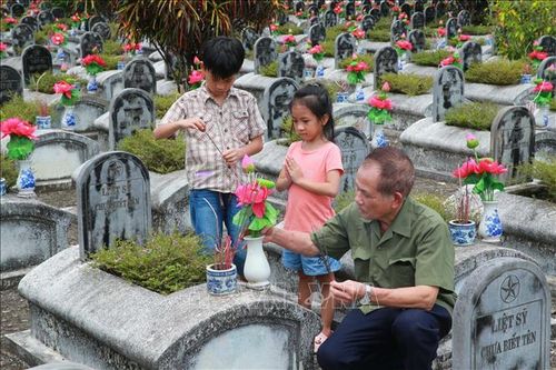 Du khách dâng hương tại những phần mộ liệt sĩ chưa xác định thông tin tại Nghĩa trang Liệt sĩ Quốc tế Đồng Tâm.