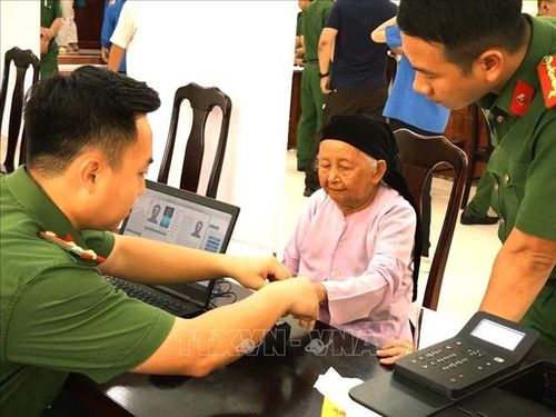 Cán bộ Công an tỉnh Tuyên Quang hướng dẫn thân nhân liệt sĩ hoàn thiện thông tin phục vụ thu nhận mẫu sinh phẩm ADN. Ảnh: TTXVN phát