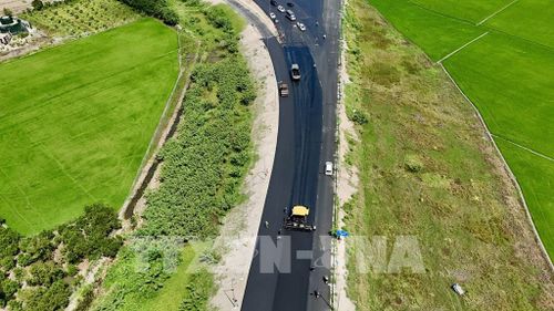 Nhà thầu đẩy nhanh thi công thảm nhựa đường dẫn từ Quốc lộ 91 (phường Vĩnh Tế, tỉnh An Giang) vào điểm đầu tuyến cao tốc Châu Đốc - Cần Thơ - Sóc Trăng. Ảnh: Thanh Sang - TTXVN
