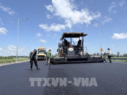 Nhà thầu đẩy nhanh thi công thảm nhựa đường dẫn vào tuyến cao tốc Châu Đốc - Cần Thơ - Sóc Trăng tại phường Vĩnh Tế, tỉnh An Giang. Ảnh: Thanh Sang - TTXVN