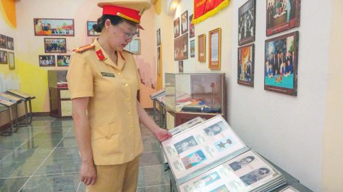 Trung tá Lâm Trịnh Quỳnh Hương xem lại tư liệu về người cha tại phòng truyền thống. Ảnh: Lê Tiến
