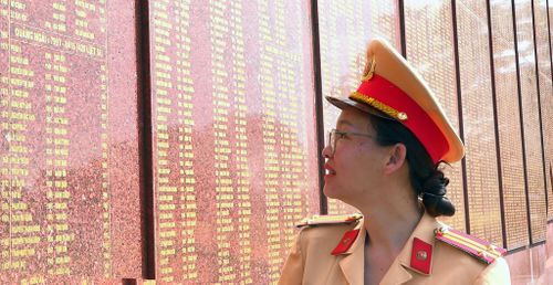 Trung tá Lâm Trịnh Quỳnh Hương tìm tên người cha, Anh hùng Lực lượng vũ trang nhân dân, Liệt sĩ Lâm Văn Thạnh, trên bia tưởng niệm các Anh hùng liệt sĩ. Ảnh Lê Tiến
