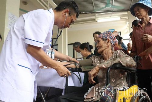 Các y, bác sĩ Bệnh viện Quân y 103 đo huyết áp cho người cao tuổi, gia đình chính sách tại Trạm y tế phường Kỳ Sơn.