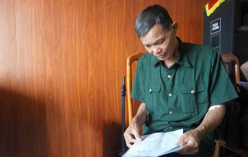 Ông Nguyễn Văn Tán (xã Hoàn Lão) giữ gìn giấy báo tử, sợi dây kết nối gia đình với người anh liệt sĩ đã nằm lại chiến trường hơn nửa thế kỷ - Ảnh: N.M