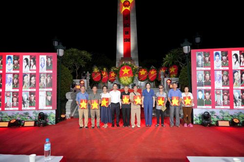 Bà Đặng Thị Huyền, Bí thư Đảng ủy, Chủ tịch HĐND xã trao tặng di ảnh liệt sĩ cho các thân nhân gia đình liệt sĩ. Ảnh: Nguyễn Sơn