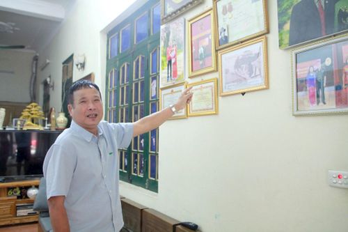 Ông Nguyễn Như Bích chia sẻ với phóng viên bức ảnh ghi lại trận “Điện Biên Phủ trên không" những ngày cuối tháng 12-1972 do chuyên gia Liên Xô chụp khi ông đang sửa chữa xe tăng. Ảnh: Hồng Nhung