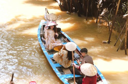  Du khách trẻ ngồi xuồng ba lá tại cồn Thới Sơn ngày 18/7. Ảnh: Trúc Hồ. 
