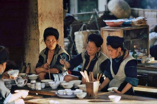  Grumpe ghi lại khoảnh khắc người H'Mông ăn sáng giữa phiên chợ vùng cao. Ông đặc biệt ấn tượng với những bộ trang phục nhuộm chàm thủ công, đôi khuyên tai bạc cỡ lớn của phụ nữ, tục cạo lông mày và chiếc khăn đội đầu màu đỏ đặc trưng của người Dao. 