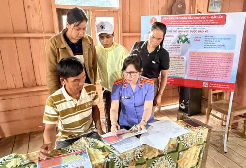 Kiểm sát viên VKSND khu vực 1, tỉnh Đắk Lắk tuyên truyền về Nghị quyết 205/2025/QH15 cho bí thư buôn và người dân.