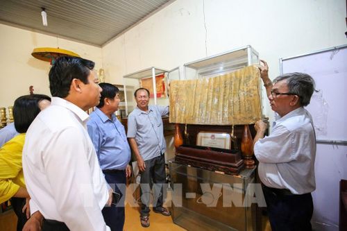 Ban Quản lý Khu di tích Lăng mộ Quan lớn Trà Vong giới thiệu các hiện vật, sắc phong được lưu giữ tại di tích. Ảnh: Giang Phương – TTXVN