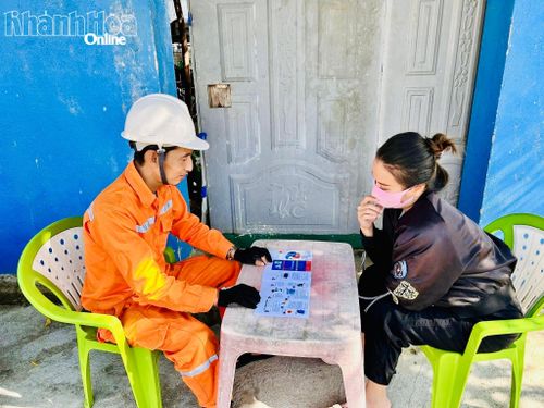 Nhân viên Công ty Điện lực Khánh Hòa hướng dẫn khách hàng sử dụng các dịch vụ điện trực tuyến và thanh toán không dùng tiền mặt.