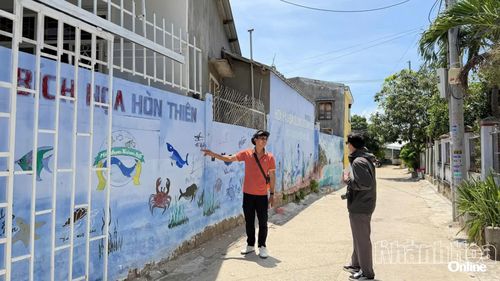 Hướng dẫn viên giới thiệu về các bức tranh tại làng.