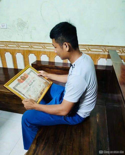 Anh Hoàng Văn Hiếu ở xã Na Dương, tỉnh Lạng Sơn, là cháu của liệt sĩ Hoàng Văn Mốc nâng niu tấm bằng Tổ quốc ghi công của người bác đã hy sinh.