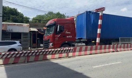 Xe container vượt chiều cao khung bảo vệ cầu đường sắt.
