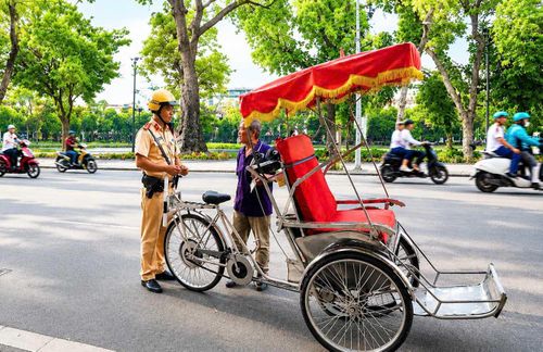 Chiến sĩ Đội Cảnh sát giao thông số 1, Phòng Cảnh sát giao thông (Công an thành phố Hà Nội) kiểm tra xe xích lô tại phố Đinh Tiên Hoàng (phường Hoàn Kiếm). Ảnh: Tâm Hiền