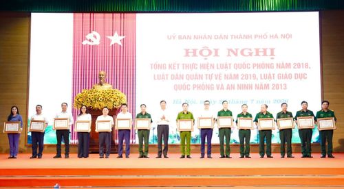 Phó Chủ tịch UBND thành phố Hà Nội Đỗ Anh Tuấn trao Bằng khen cho các tập thể có thành tích trong công tác triển khai thực hiện các luật. Ảnh: Hồng Thái