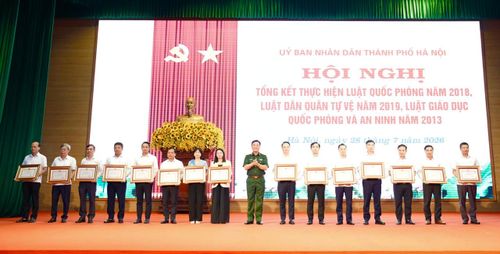 Thiếu tướng Đào Văn Nhận trao Bằng khen cho các tập thể, cá nhân có thành tích trong công tác triển khai thực hiện các luật. Ảnh: Hồng Thái