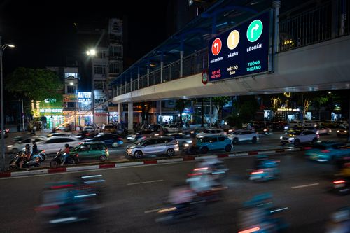  Màn hình LED cập nhật giao thông hiển thị nổi bật trong khung giờ buổi tối trên phố Trần Khát Chân. Các bảng LED sử dụng hệ thống mã màu để phản ánh tình trạng giao thông theo thời gian thực. Trong đó, màu xanh thể hiện tuyến đường thông thoáng, màu vàng báo hiệu lưu lượng phương tiện cao, còn màu đỏ cảnh báo ùn tắc. Nhờ đó, người dân có thể chỉ cần quan sát màu sắc hiển thị để nắm bắt nhanh tình hình giao thông và chủ động điều chỉnh lộ trình, tránh các điểm ùn ứ. 