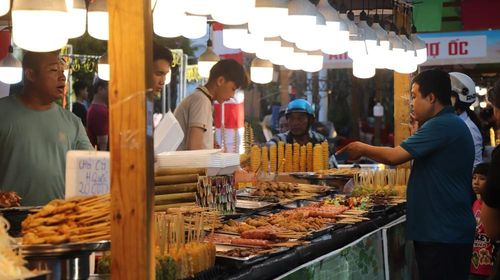 Du khách lựa chọn các món nướng và ăn vặt đa dạng tại gian hàng ẩm thực. Ảnh: Nguyễn Hằng - TTXVN
