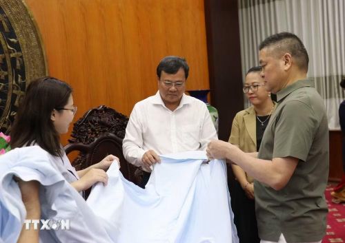 Đại diện Tập đoàn Công nghệ TENFY giới thiệu các sản phẩm công nghệ thời trang thông minh do doanh nghiệp nghiên cứu, phát triển, thể hiện định hướng ứng dụng công nghệ, đổi mới sáng tạo trong sản xuất. (Ảnh: Bùi Giang/TTXVN)