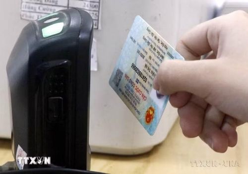 Dùng máy quét QR code trên căn cước gắn chip để tra cứu thông tin người bệnh. (Ảnh: Đồng Thúy/TTXVN)