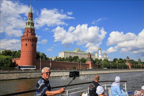 Du khách ngắm nhìn quần thể kiến trúc Điện Kremlin từ tàu du lịch trên sông Moskva.