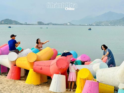 Người dân và du khách thích thú lưu lại khoảnh khắc trên những khối bê tông chắn sóng đầy sắc màu.