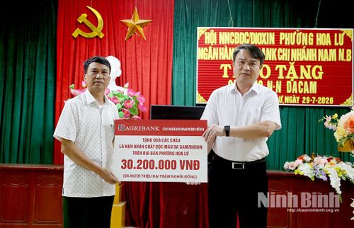 Đại diện lãnh đạo Agribank Chi nhánh Nam Ninh Bình trao biểu trưng 30,2 triệu đồng hỗ trợ cho Hội NNCĐDC/Dioxin phường Hoa Lư.