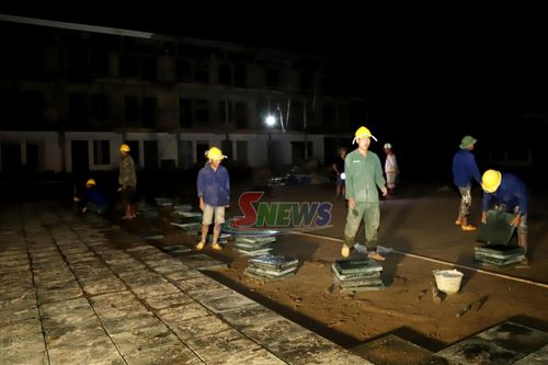 Công nhân thi công lát gạch block sân trường.