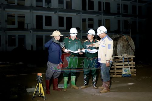 Cán bộ kỹ thuật và chủ đầu tư kiểm tra tiến độ thực hiện dự án.