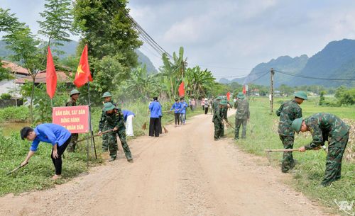 Cán bộ, chiến sĩ Lữ đoàn 575 và đoàn viên thanh niên vệ sinh môi trường, làm sạch các tuyến đường liên thôn xã Quang Sơn.