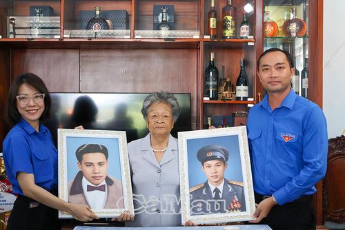 Anh Phạm Tuấn Tài, , Phó Chủ tịch Uỷ ban MTTQ Việt Nam tỉnh Cà Mau, Bí thư Tỉnh đoàn Cà Mau, trao ảnh 2 liệt sĩ là chồng và con trai cho Mẹ Việt Nam Anh hùng Phan Kim Mai, phường Hoà Thành.