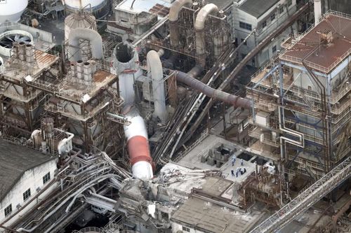 Đội cứu hộ khẩn cấp Kumamoto thông tin thêm ống khói tại nhà máy Yatsushiro của Nippon Paper Industries bị sập khiến nhiều người mắc kẹt dưới đống đổ nát. Tính đến sáng hôm 29/7, vẫn còn 7 người được cho là đang bị mắc kẹt, 2 người sống sót và 2 thi thể được đưa ra ngoài. (Ảnh: Kyodo News)