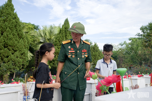 Các em nhỏ lắng nghe cựu chiến binh kể về những năm tháng chiến đấu bảo vệ biên giới và sự hy sinh của đồng đội trên mặt trận Vị Xuyên. 