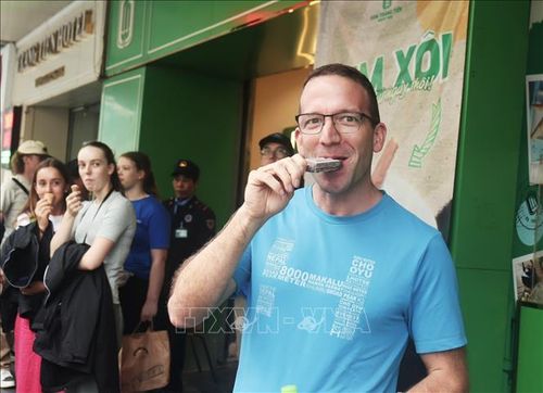 Du khách ăn kem Tràng Tiền, đặc sản hơn 60 năm của Hà Nội. Ảnh tư liệu: Mai Hiền/TTXVN phát