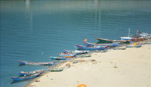Những chiếc thuyền thúng và ghe đánh cá neo đậu trên vịnh Lăng Cô lặng lẽ trên mặt biển với nhiều màu sắc hòa trộn với nhau.