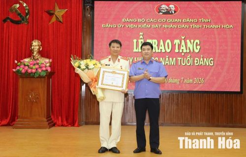 Bí thư Đảng ủy, Viện trưởng Viện Kiểm sát Nhân dân tỉnh Nguyễn Tiến Dũng trao Huy hiệu 30 năm tuổi Đảng cho đảng viên Lê Đình Tiến.
