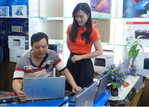 Phụ huynh kiểm tra laptop trước khi mua cho con.