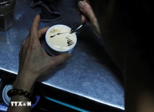 Người pha chế trang trí cho ly càphê trứng với hình ảnh Tháp Rùa. (Ảnh: Lâm Khánh/ TTXVN)