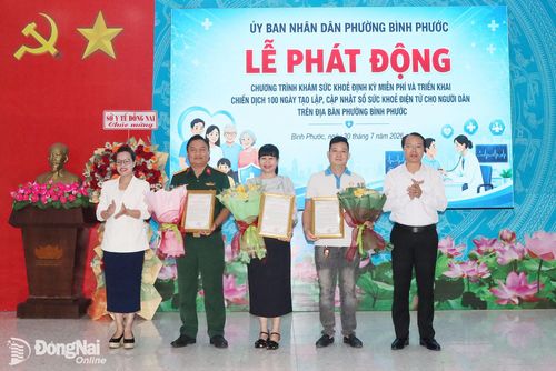 Lãnh đạo phường Bình Phước tặng hoa và thư cảm ơn các đơn vị y tế đồng hành cùng chương trình. Ảnh: Quang Minh