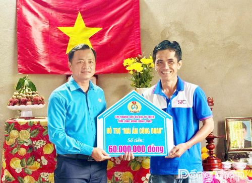 Đồng chí Nguyễn Thanh Tuấn, Phó Chủ tịch Liên đoàn Lao động tỉnh trao bảng tượng trưng hỗ trợ kinh phí xây dựng “Mái ấm Công đoàn” cho anh Dương Minh Phụng.