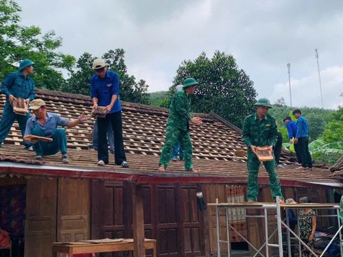 Cán bộ, chiến sĩ Đồn Biên phòng Làng Mô giúp dân lợp nhà - Ảnh: X.V