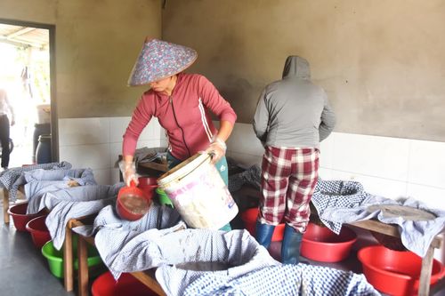 Công đoạn đổ chượp vào dụng cụ lọc nước mắm - Ảnh: Đ.V