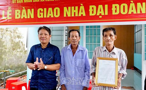 Đồng chí Hồ Văn Nguơn, Phó Bí thư Thường trực Đảng uỷ xã Hưng Mỹ trao quyết định bàn giao nhà, chúc gia đình ông Phạm Minh Thanh (bìa phải) sớm ổn định cuộc sống, yên tâm lao động, phát triển kinh tế gia đình.